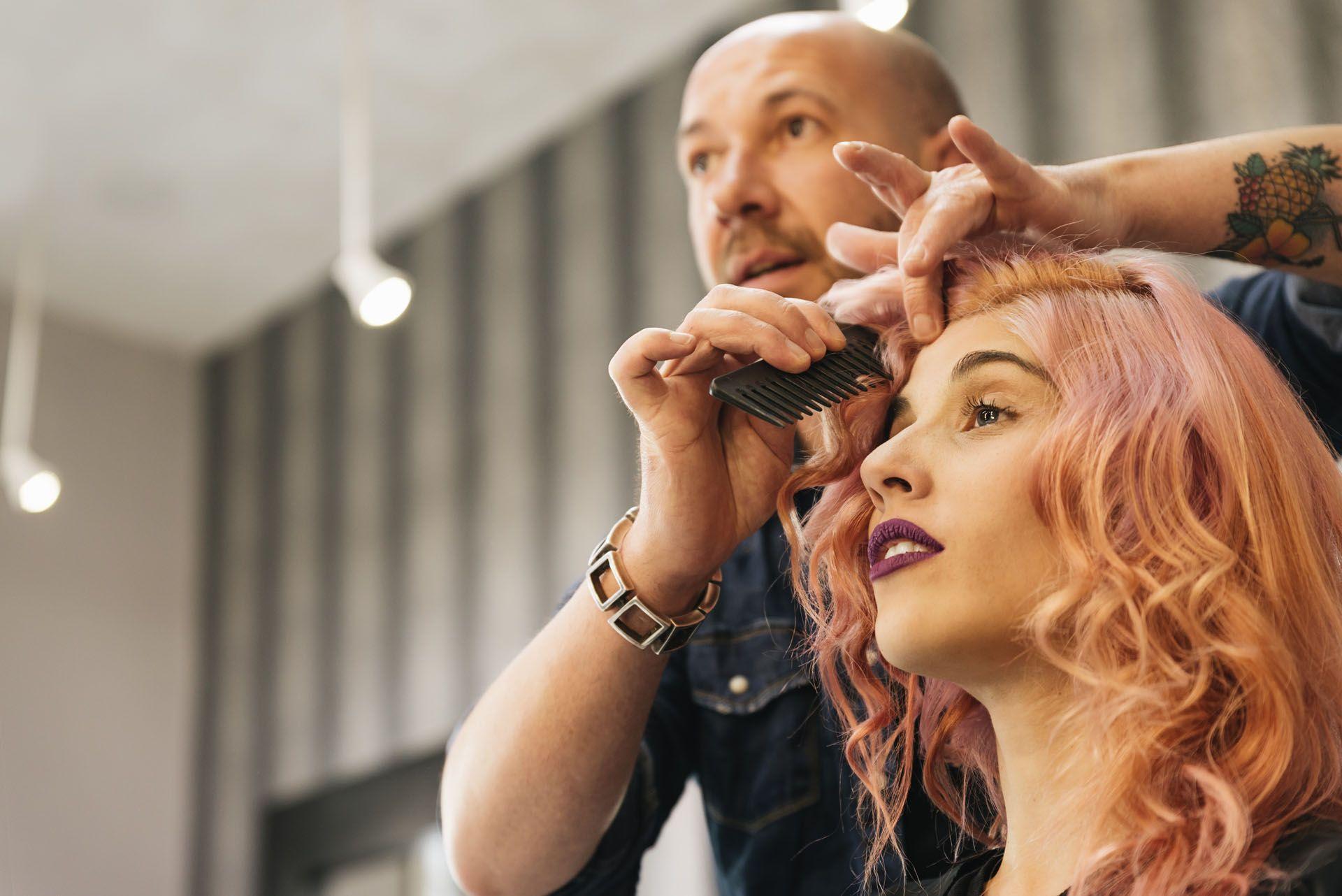 Un coiffeur entrain de finaliser la coiffure de sa cliente