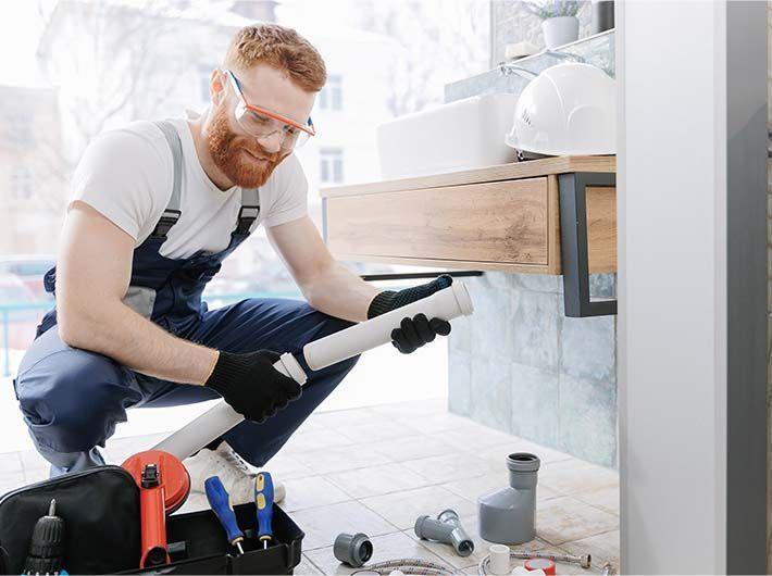 Un monteur en installations sanitaires dans l'exercice de sa pratique