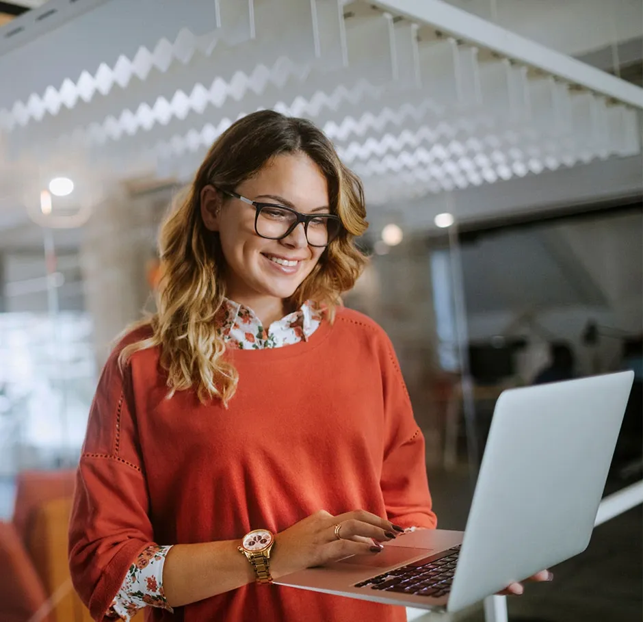 Apprenante en formation création d’entreprise travaillant sur son projet entrepreneurial sur ordinateur dans un espace de coworking