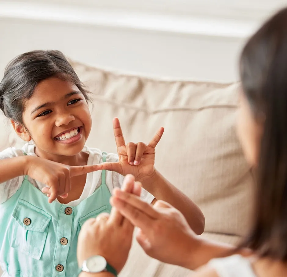 Apprenant en formation langue des signes communiquant avec une enfant sourde lors d’un atelier pédagogique