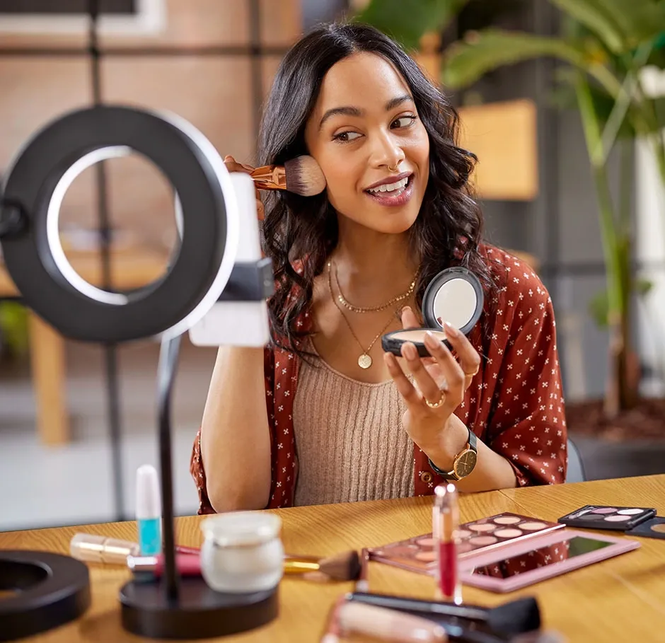 Apprenante en formation maquillage mode et médias réalisant un tutoriel maquillage face caméra dans un cadre professionnel