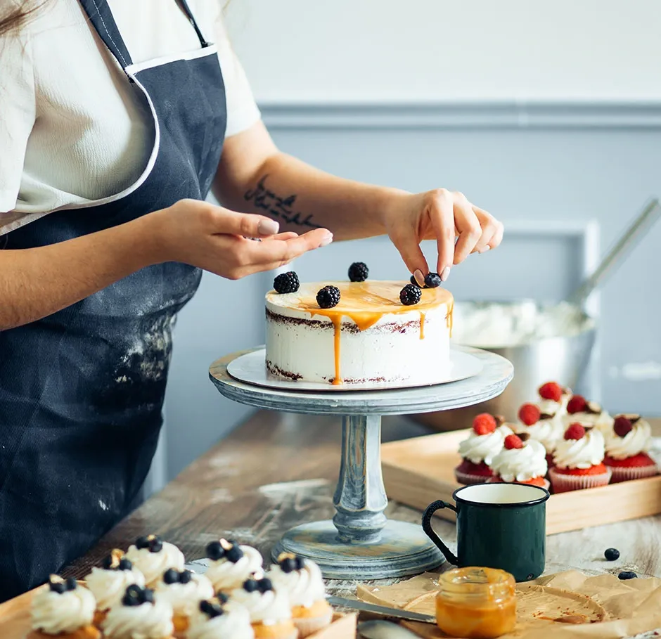 Apprenante en formation pâtisserie décorant un entremets au caramel et aux mûres dans le cadre d’un parcours CAP complet